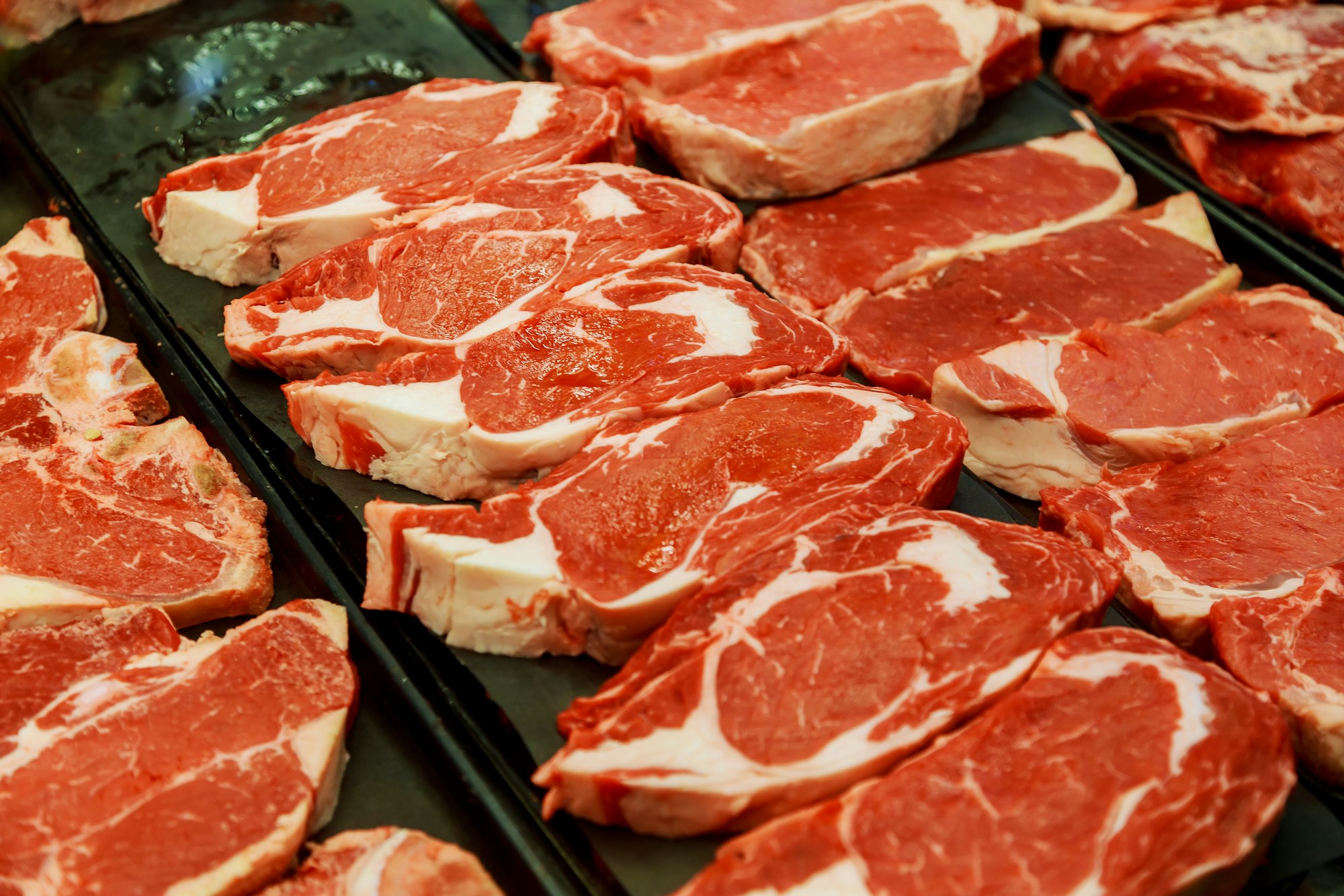 Selection of different cuts of fresh raw red meat in a supermarket